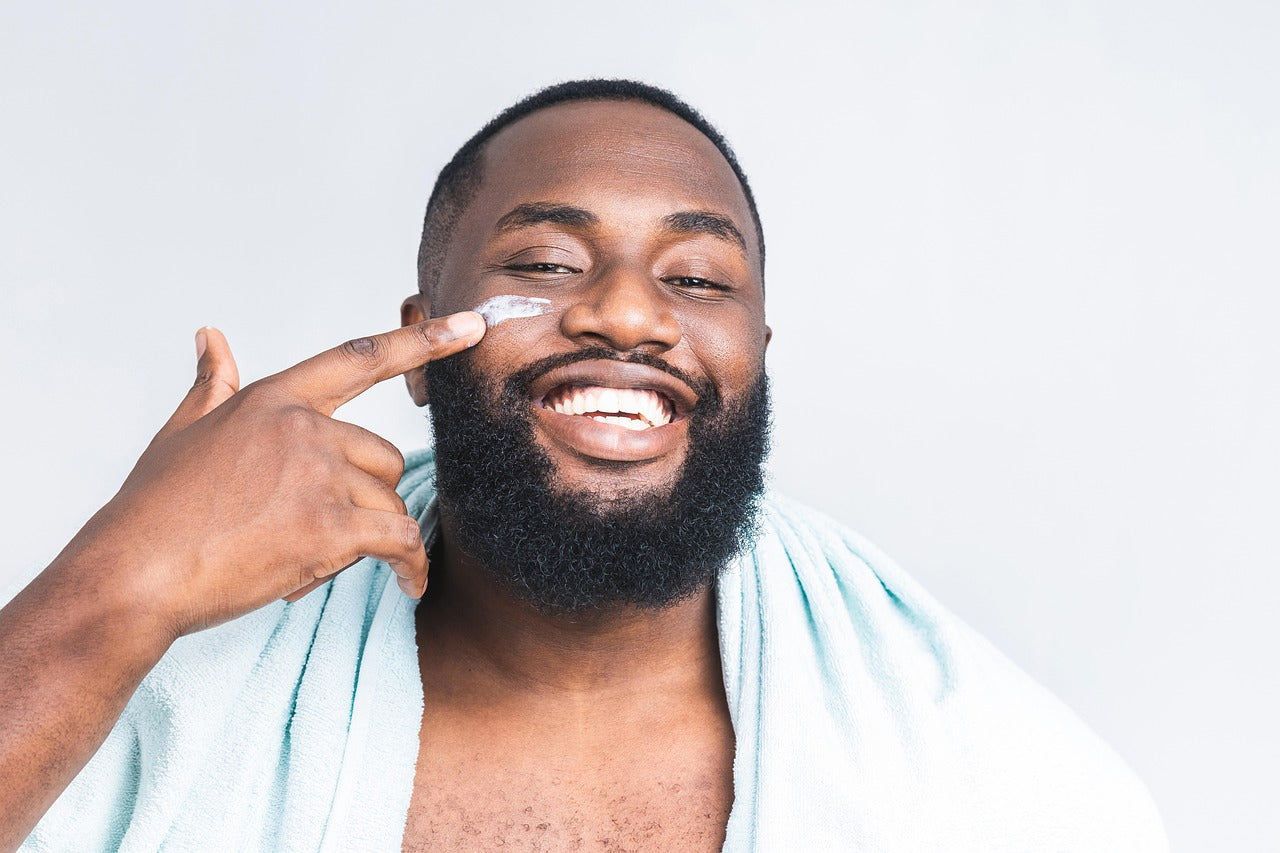 Young man applying Ultimate Hydration moisturizer to his skin as part of a gentle skincare routine for dry, sensitive skin.